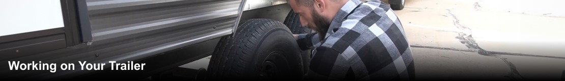 A man changing a tire on an RV.